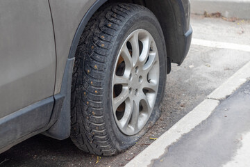 Fototapeta na wymiar broken car wheel close-up. rubber tire with spikes on the wheel