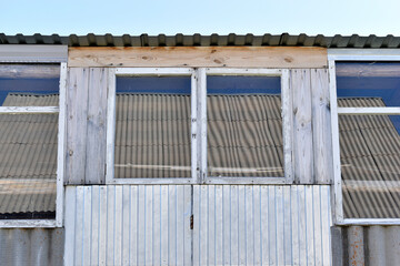 An old greenhouse of rotten windows with cracked paint