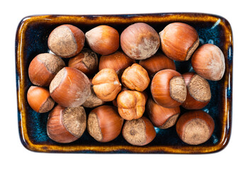 top view of ripe hazelnuts in bowl cutout on white