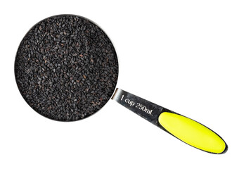 view of black sesame seeds in measuring cup cutout