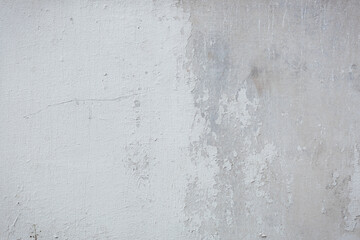 The texture of the white stucco wall with scratches, cracks, dust, crevices, roughness. Can be used as a poster or background for design.