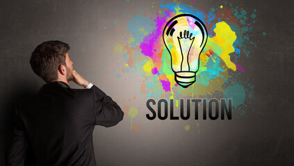 businessman drawing colorful light bulb