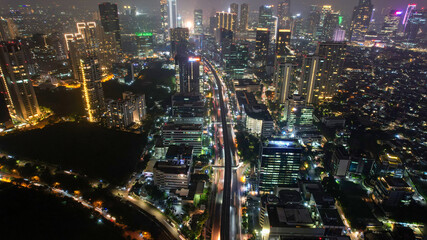 Fototapeta na wymiar Aerial view of highway intersection and buildings in the city of Jakarta at night and noise cloud with Jakarta cityscape. Jakarta, Indonesia, May 8, 2021