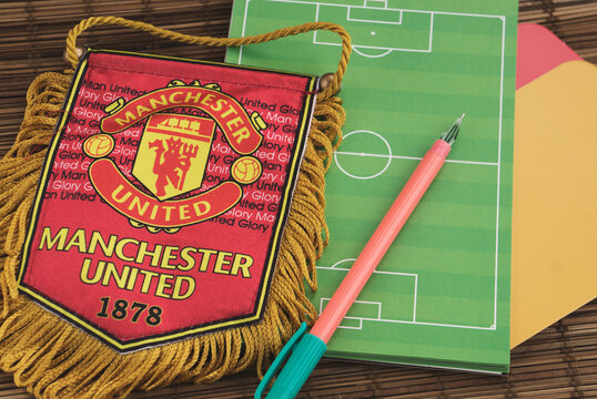 Krasnodar, Russia, 14 September 2020: Getting ready for watching the match: Sports pennant (symbol) of Manchester United, picture of football (soccer) field, pen, yellow and red cards.