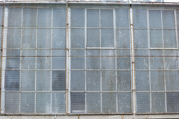 old warehouse windows covered wire mesh screens