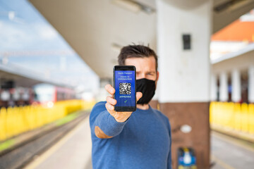 health Vaccine Passport for Coronavirus or Covid-19. Traveller Using Mobile Phone with Vaccination in Immune Status to Certificated International Traveling in train station