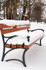 ławka w parku pokryta śniegiem, zima