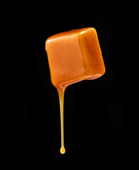 caramel sauce flowing on flying caramel candy
