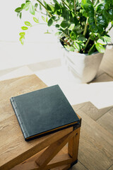 Photo books made of genuine leather cover for storing photos. Stylish diaries for entries for the week. Photo albums and books of literature are lying on a wooden chair.