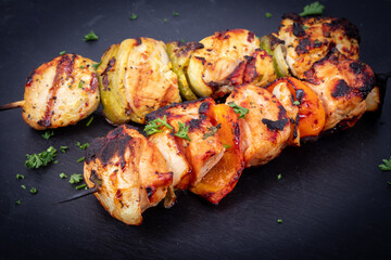 Raw chicken skewers in marinade with spices and herbs