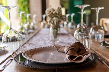 Mesa Montada para comida con cubiertos platos copas mantel y flores