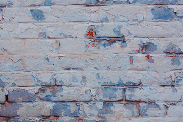 Texture of an old brick wall with shabby blue plaster. Natural damage to the paintwork. Natural aging concept.