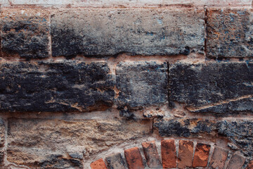 Old shabby wall with elements of destroyed bricks. Dark brick background. Can be used as background for design or poster.