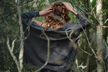 Beautiful women model relaxing in nature, forest. Long blond hair and stylish cozy clothes