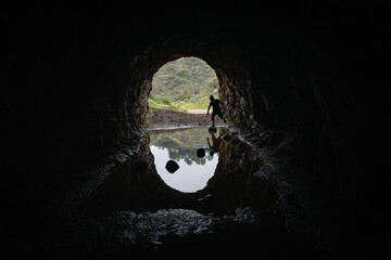 Silhouette of man running across stones in dark cave in Bronson Canyon, Los Feliz, Los Angeles