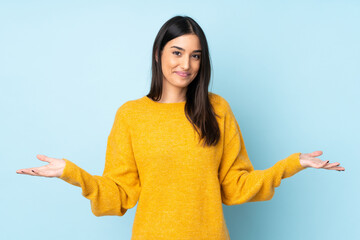 Young caucasian woman isolated on blue background having doubts