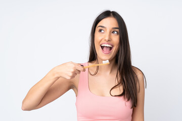 Young caucasian woman isolated on white background with a toothbrush