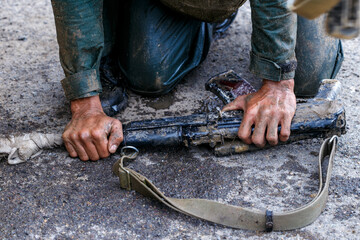 Close-up. The soldier leaned against the ground with a combat submachine gun