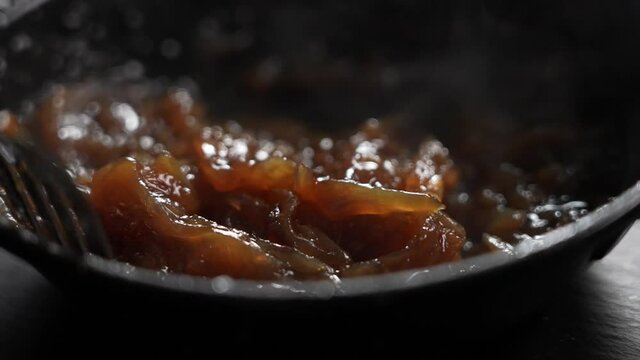 Cooking juicy and tasty caramelized onion to make a burger. Gourmet restaurant food in slow motion.