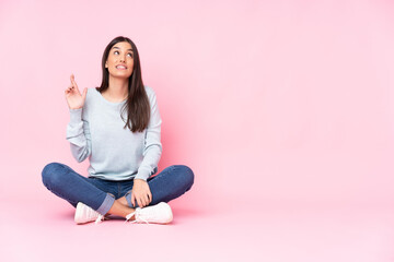 Fototapeta na wymiar Young caucasian woman isolated on pink background with fingers crossing and wishing the best