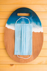 mask on wooden board background with waves.Covid travel restrictions concept