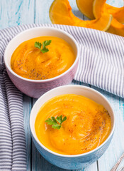 Traditional autumn pumpkin soup-puree on a blue background.