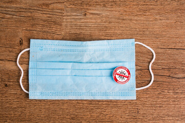 medical mask with words stop coronavirus on wooden boards