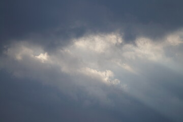 Dramatischer Wolken verhangener Himmel mit diagonalen Sonnen Strahlen 
