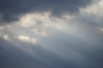 Naklejka na ściany i meble Dramatischer Wolken verhangener Himmel mit diagonalen Sonnen Strahlen 