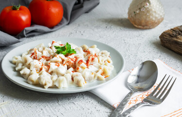 Turkish traditional food ravioli with yoghurt and tomato sauce in plate, manti
