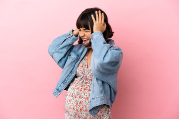 Young pregnant woman over isolated pink background stressed overwhelmed