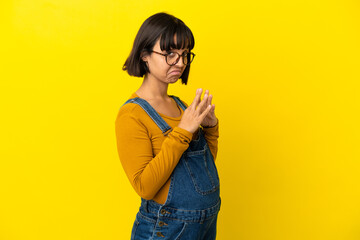 Young pregnant woman over isolated yellow background scheming something
