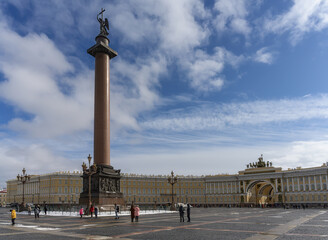 Fototapeta na wymiar View of Palace Square (St. Petersburg, Russia) with the Alexander Column made of solid pink granite and a bronze pedestal. In the distance, the Arch of the General Staff in early spring. Blue sky 