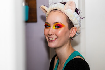 Teenage girl smiles at camera while applying makeup