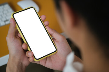 Close up view of businessman holding mock up smart phone with blank screen.