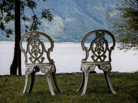 Two chairs looking to a lake and mountains behind. Caburgua, Chile.