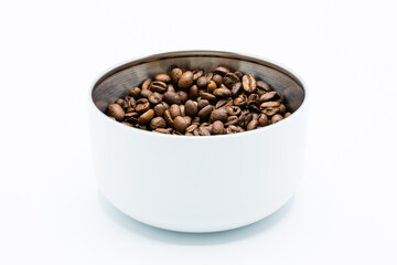 Mixture of different kinds of roasted coffee beans in white container on white background. Copy space.
