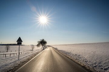 Sun star over the road in winter landscape 