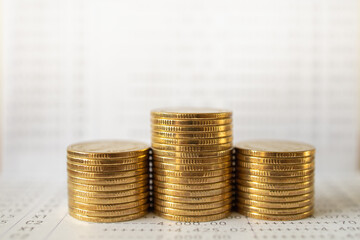 Business Money and Financial Concept. Closeup of stack of gold coins on bank passbook.