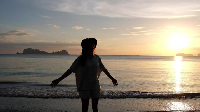 Silhouette blurred slow motion of a woman walking on the beach before sunset