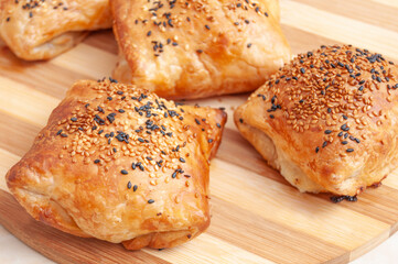 Cheese filled pastry on wooden round plate, with white and black sesame