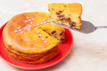 Cheese cake and a slice on a red plate