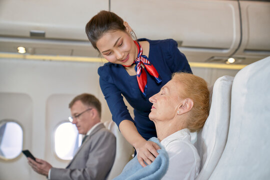 Air Hostess Girl Take Care With Grand Ma Old Woman In Flight Travel On Aircraft Cabin