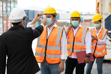 foreman scanning fever temperature with digital thermometer to workers in construction site