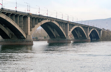 Fototapeta na wymiar Large concrete transportation bridge across wide river in Siberia.