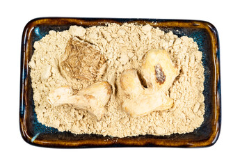 dried ginger roots and powder in bowl cutout