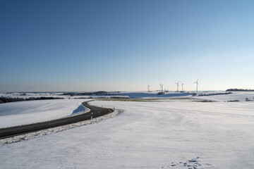 Curvy road in winter landscape with nice blue sky 