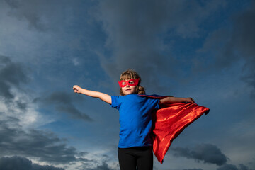 Fototapeta na wymiar Little child superhero with hero cloak. Success, motivation concept.