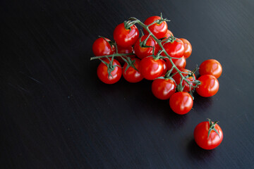 healthy food a ripe bunch of red cherry tomatoes on a dark background