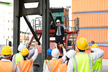 warehouse boss engineer standing on crane car with factory workers raise hand for congratulations...